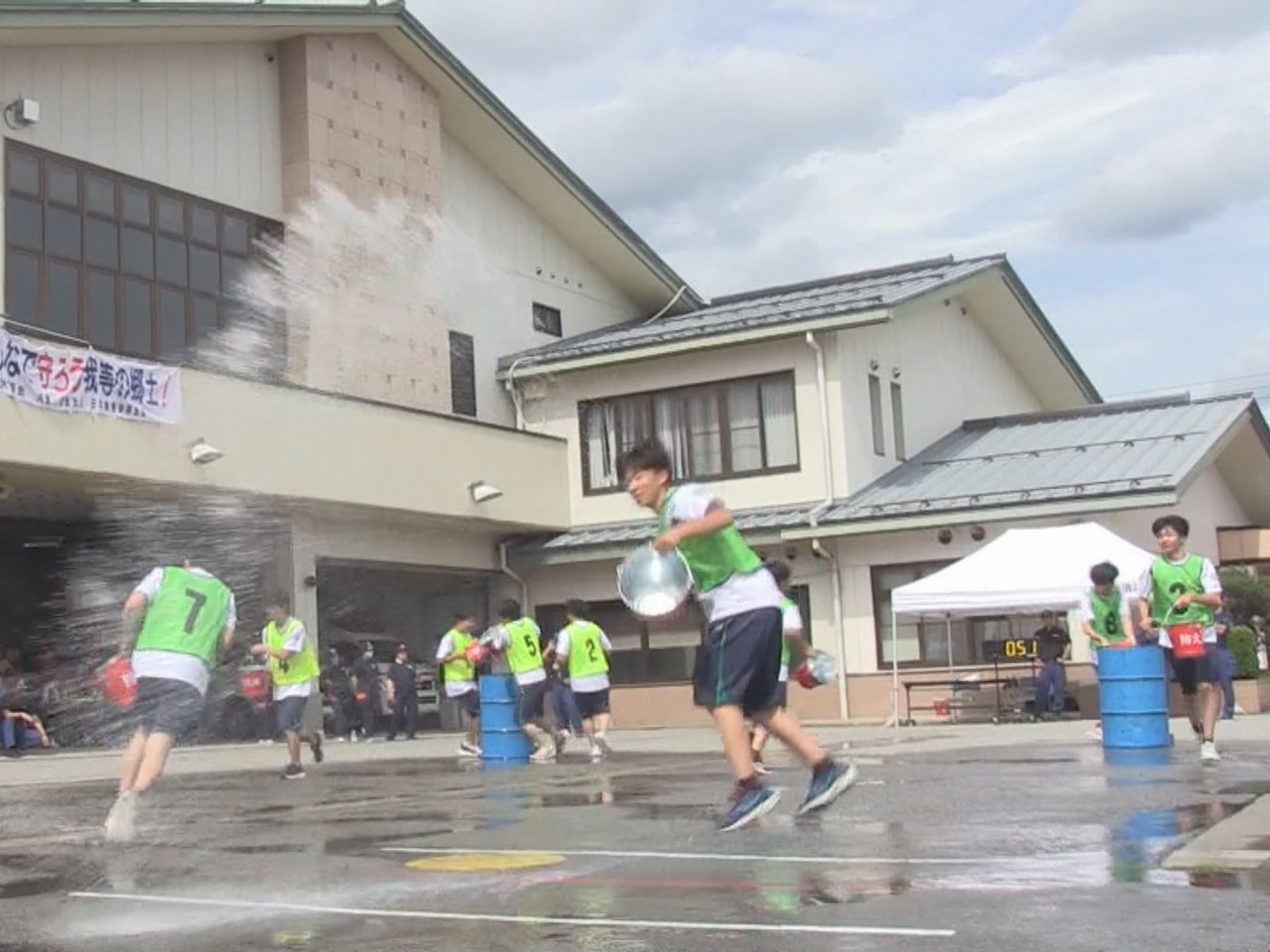 バケツにくんだ水を火元に見立てた塔へかけ、貯まった水の量を競う「バケツ注水大会」...